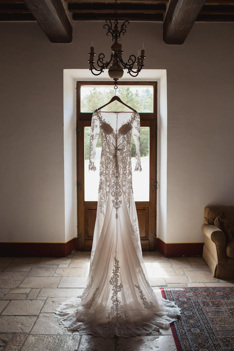 Lace wedding dress hanging in italian villa at destination wedding