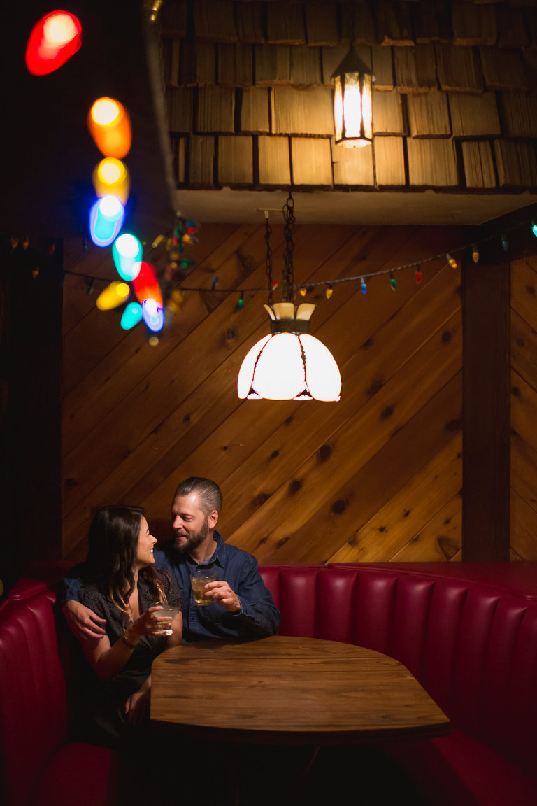 couple in red booth at dive bar captain keno's encinitas engagement session