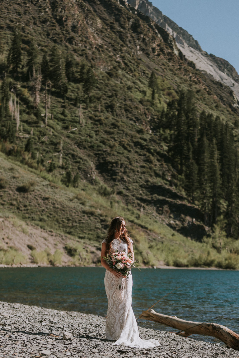 bride in lace dress stands in front of convict lake