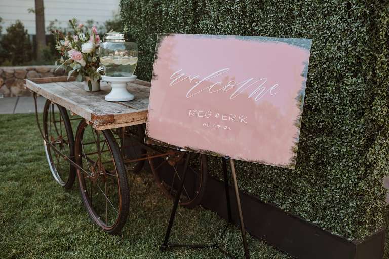 welcome sign and rustic wagon with flowers at sonoma wedding reception