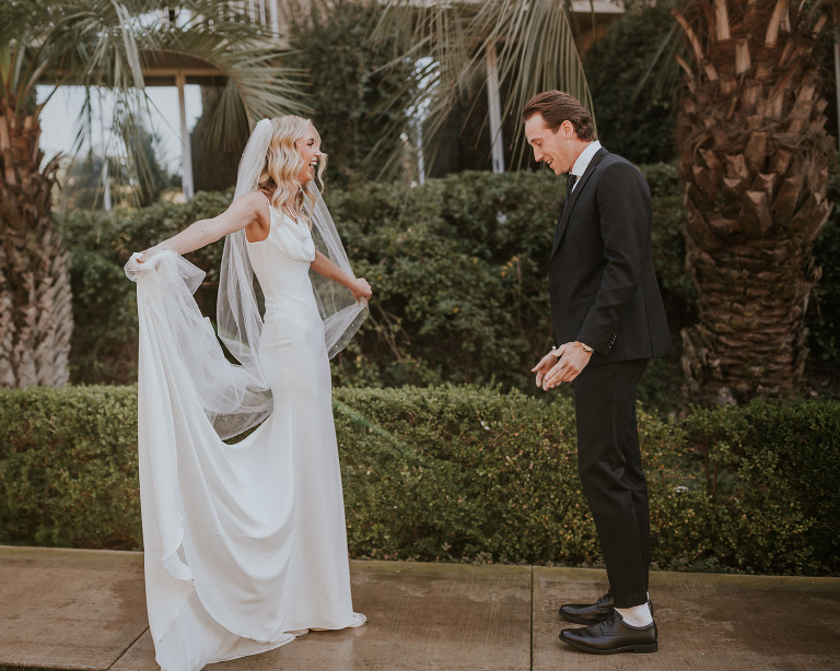 bride shows groom her dress during their first look