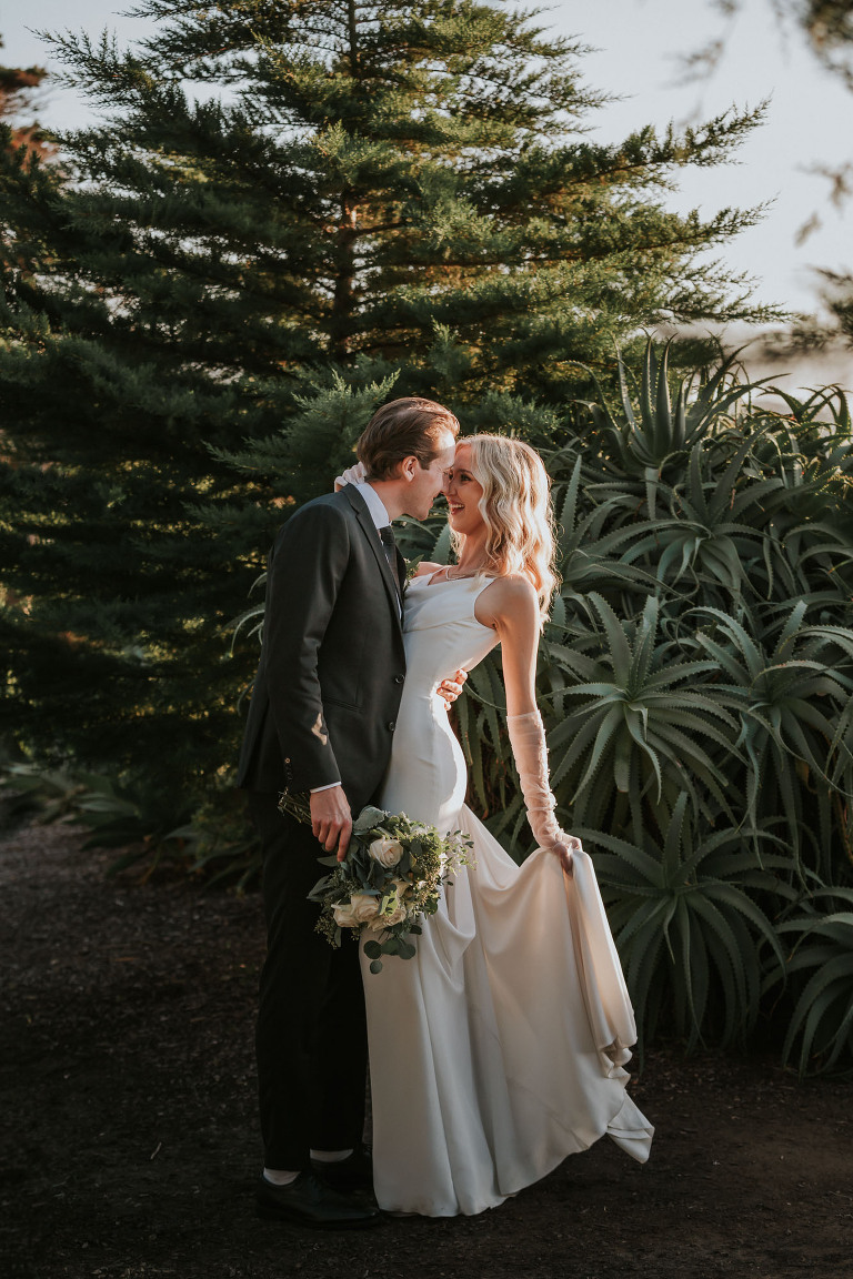 bride and groom embrace in front of succulents at martin johnson house wedding