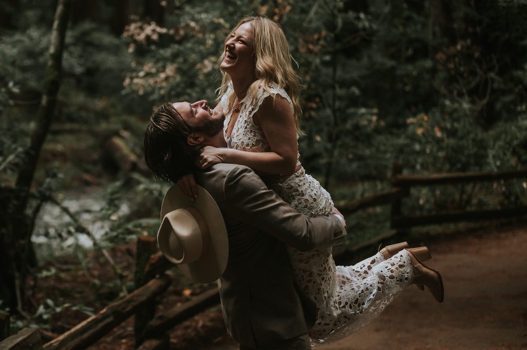 man lifts woman playfully for muir woods engagement session