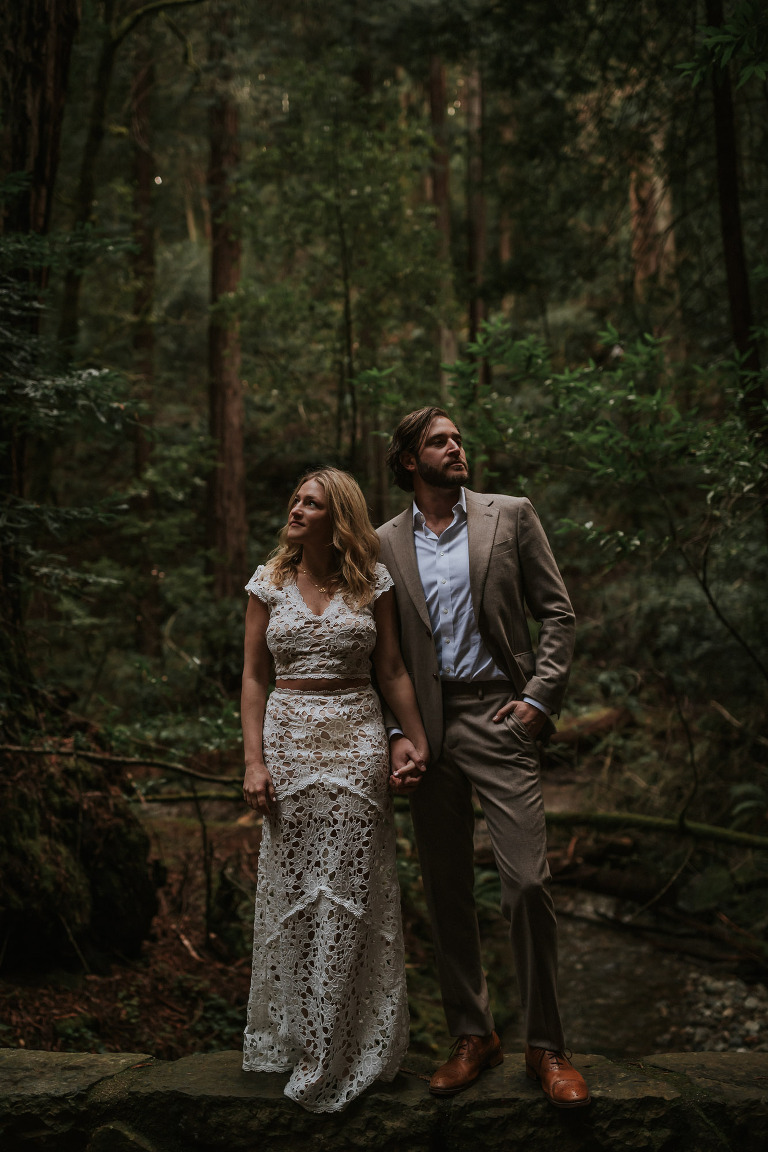 man and woman holding hands in a forest for muir woods engagement