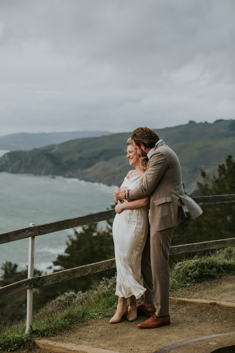 a couple in the wind above ocean at muir beach overlook