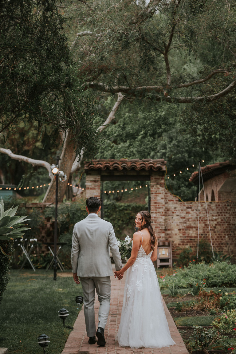 bride and groom walking through hummingbird nest ranch gardens