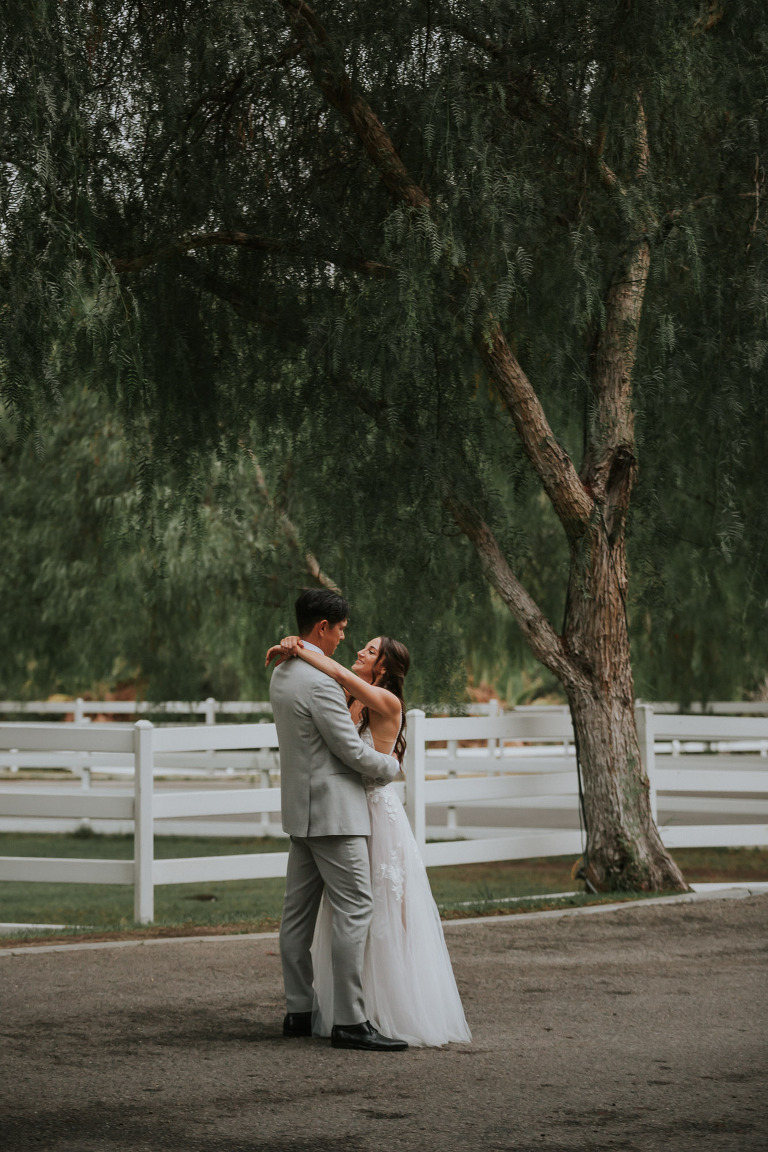 bride and groom in front of the pepper trees