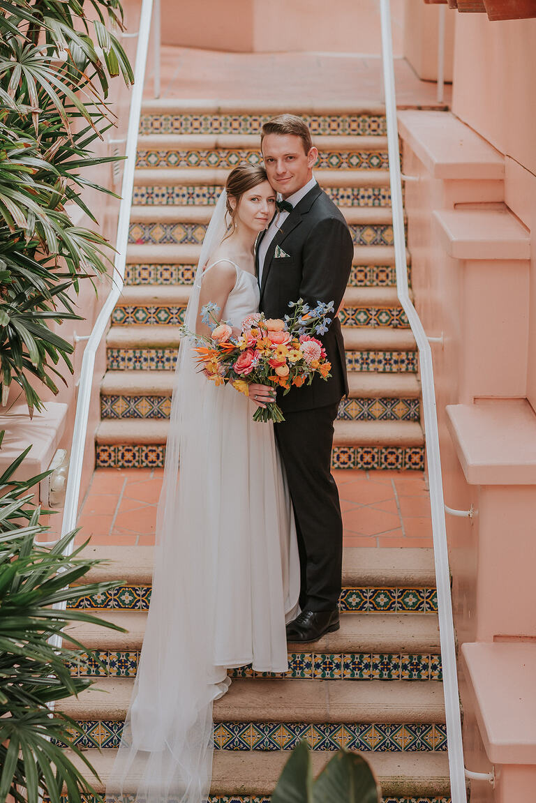 bride and groom standing on tiled stairs of la jolla's la valencia pink lady hotel