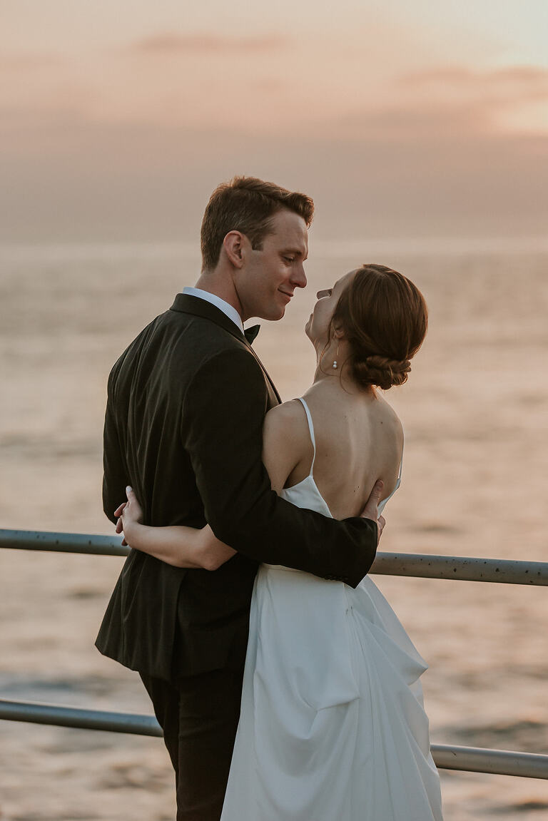 bride and groom watching the sunset over the ocean in la jolla