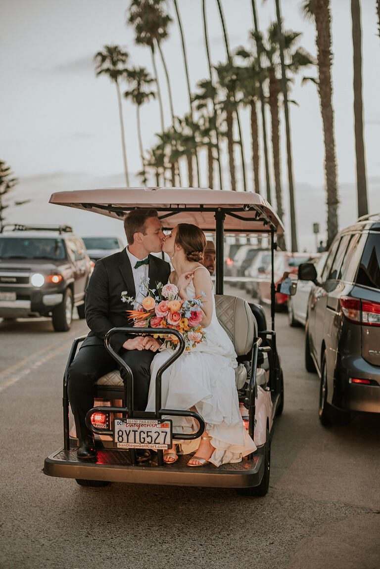 bride and groom take golf cart to the shore at la valencia wedding